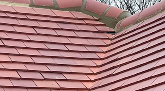 Tiled roof with visible repairs and flashing detail in residential setting