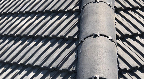 Tiled roof with a vent pipe, showcasing roofing materials and installation quality.